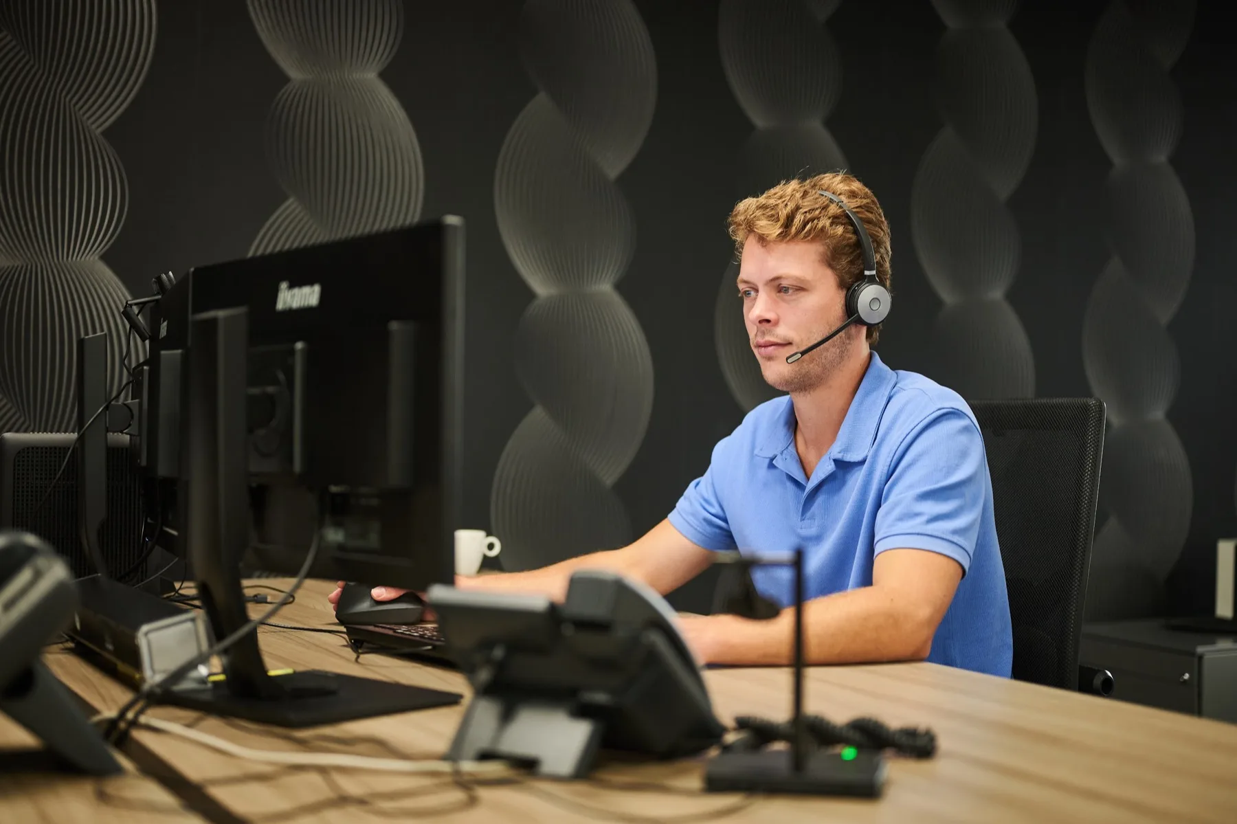 Medewerker met headset in de meldkamer in Groningen