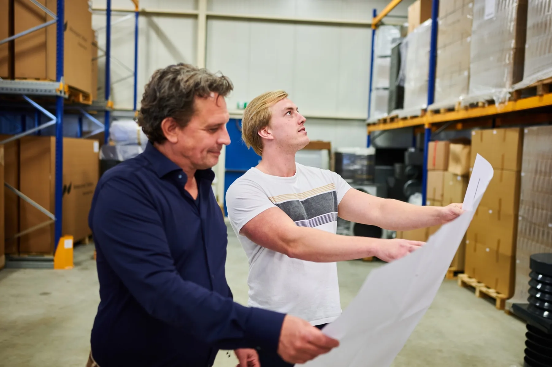 Installateurs bekijken een tekening in het magazijn